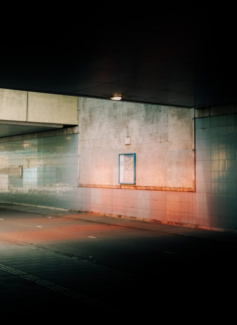 Dark underpass with a small illuminated sign, symbolizing persistence in the job search in Germany — Niv Nowbakht Business Coach Berlin